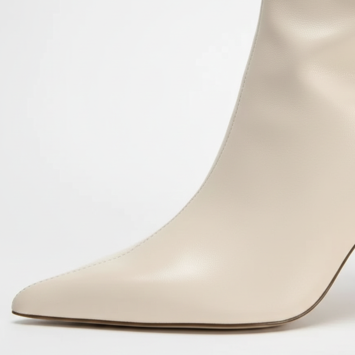 sleek white knee-high boots with a pointed toe and elegant stiletto heel.