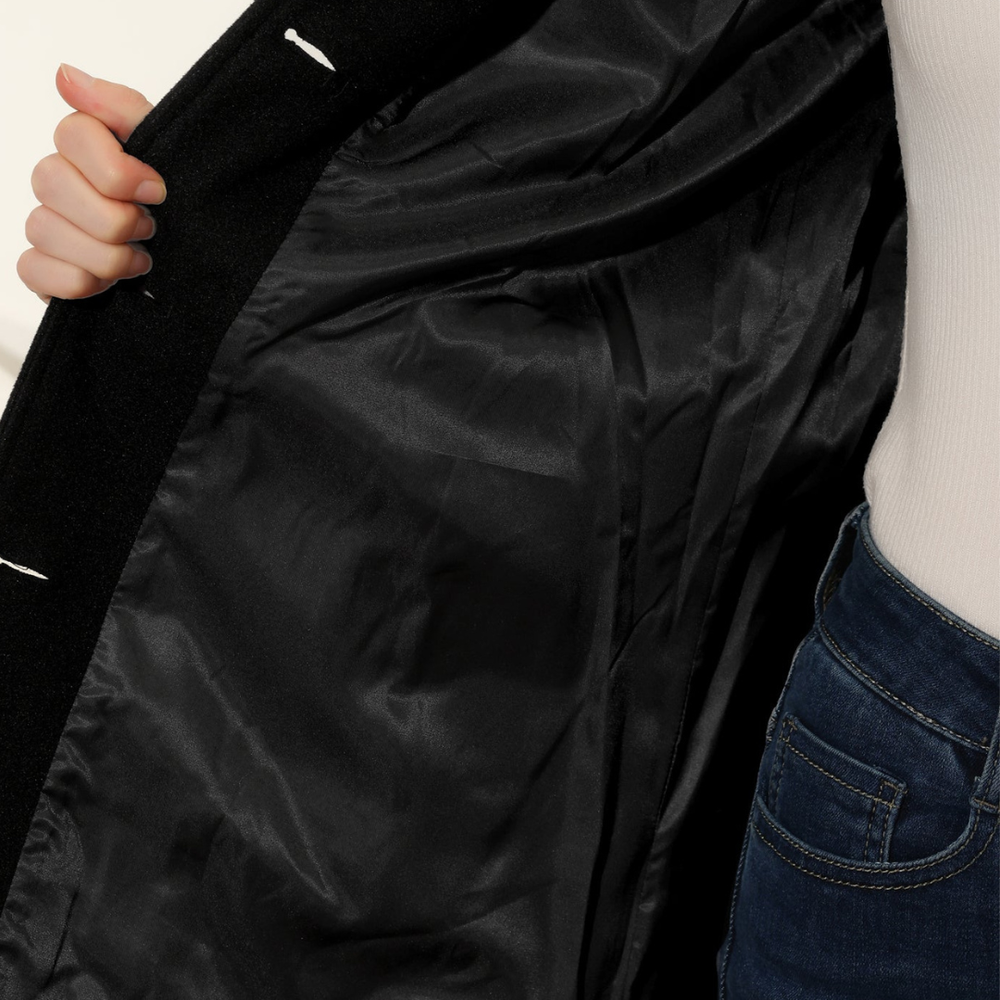 a black tailored coat paired with jeans, good for everyday wear in fall and winter.